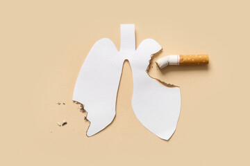 Burnt paper lungs and cigarette butt on beige background. Stop smoking concept.