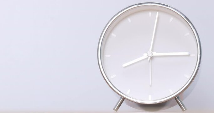 4K footage Time lapse Close-up Front view, Silver alarm clock on white background.