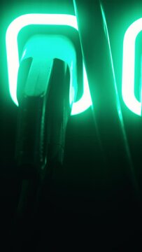 An upclose, detailed view of a brightly glowing neon light accompanied by cables