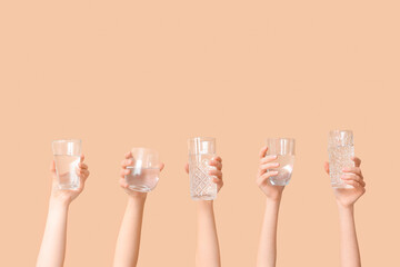 Female hands with different glasses of water on color background