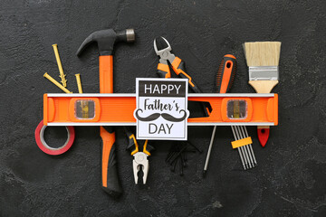 Tools and greeting card with text HAPPY FATHER'S DAY on black grunge background