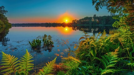 Fototapeta premium The sun setting over a calm lake in northern Europe, with the colors of the sunset reflecting in the still water, surrounded by lush greenery and a clear blue sky.
