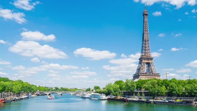 A timelapse of the Eiffel Tower along the river Seine with flyboats passing by with motion blur.Sunny but cloudy spring summer day paris city famous riverside bay tower view bridge timelapse panorama