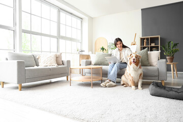 Young woman with laptop and Australian Shepherd dog at home