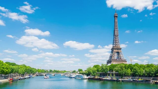 A timelapse of the Eiffel Tower along the river Seine with flyboats passing by with motion blur.Sunny but cloudy spring summer day paris city famous riverside bay tower view bridge timelapse panorama