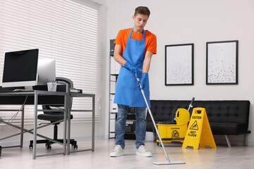 Cleaning service. Man washing floor with mop in office