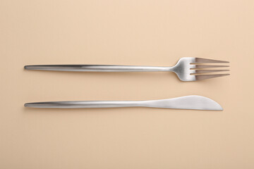 Stylish cutlery on beige table, top view