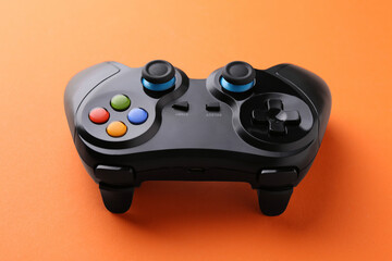 One wireless game controller on orange background