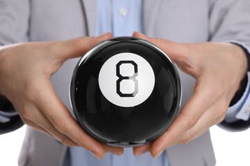 Man holding magic eight ball on white background, closeup