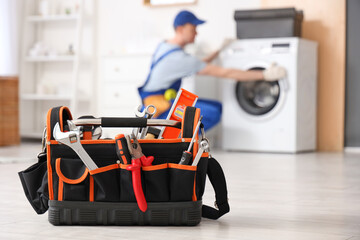 Bag with tools for repairing washing machine in bathroom, closeup