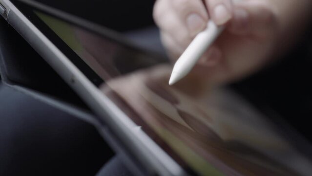 A graphic artist drawing a woman's portrait on a tablet. Close up, slow motion. 