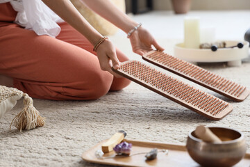 Young woman with Sadhu board on carpet at home, closeup