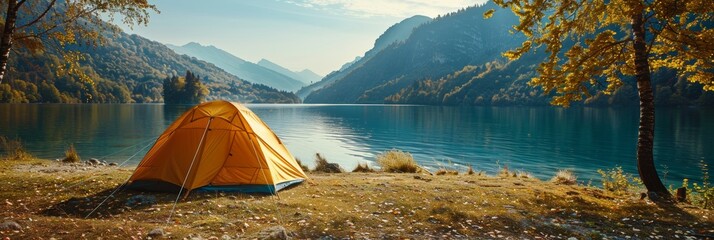 A serene camping scene featuring a bright yellow tent pitched by the edge of a tranquil lake surrounded by majestic mountains under a clear blue sky