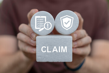 Man holding white blocks sees word: CLAIM. Claims Management Business Department Concept. Registration claim document.