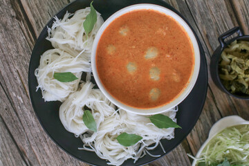 Rice noodles in a fish curry sauce with fish ball eat with vegetables. Traditional Thai food call 
