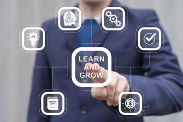 Man working on virtual touch screen presses inscription: LEARN AND GROW. Learn and grow business...
