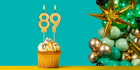 Birthday candle number 89 - Cupcake with decoration on a green background