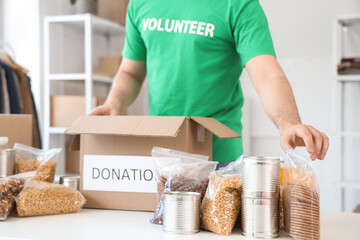Male volunteer donating food in center, closeup