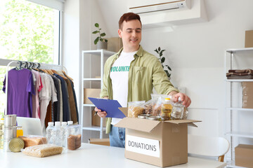 Male volunteer with clipboard and donations in center