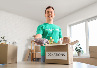 Male volunteer with food donations in center