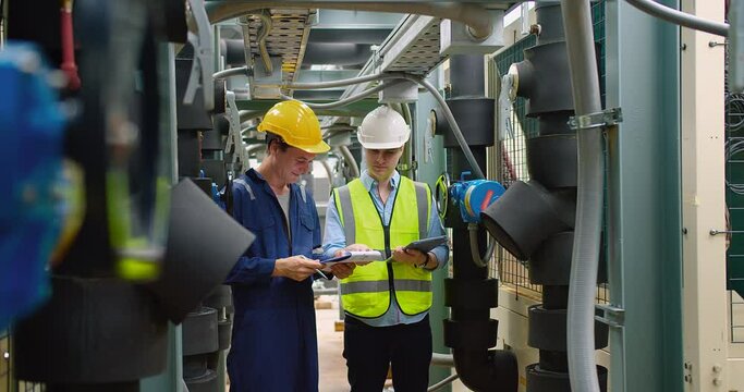 Civil engineer manager and foreman worker checking industry cooling air conditioner water cooling tower air chiller of large industrial building to control air system at construction site