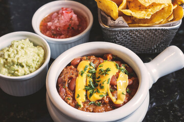 Crispy nachos accompanied by chili with meat, guacamole sauce and pico de gallo.