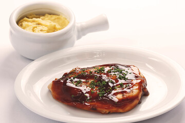 Slow cooked chicken breast in a bbq sauce accompanied by mashed potatoes.
