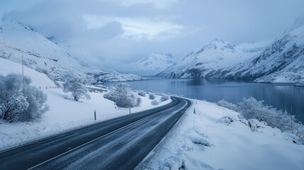 Road through snowy mountains and lake