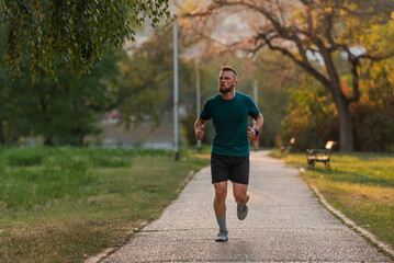 Young athletic man running or jogging at the park active healthy lifestyle.