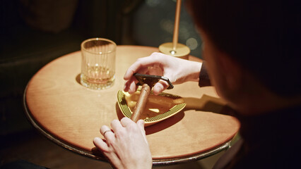 Close-up of man cutting cigar. Media. Man cuts off edge of Viagra for smoking. Professional cigar...