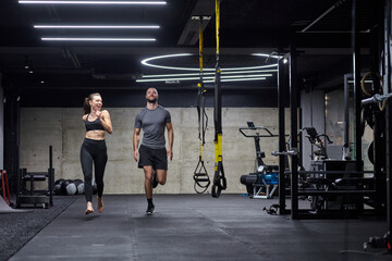 A fit couple in a modern gym, engaging in running exercises and showcasing their athletic prowess...