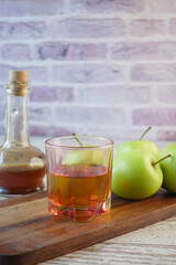 apple vinegar in glass bottle with fresh green apple on table 