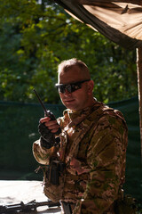 A military major employs a Motorola radio for seamless communication with his fellow soldiers during a tactical operation, showcasing professionalism and strategic coordination