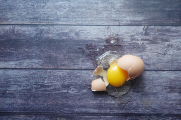 Fresh broken egg on wooden table 
