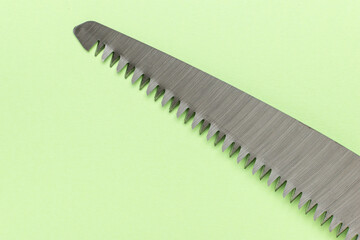 Close-Up of Serrated Knife Blade on Light Green Background for Kitchen and Culinary Use