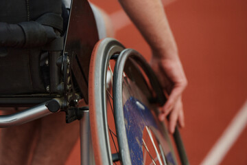 Close up photo of a person with disability in a wheelchair training tirelessly on the track in...
