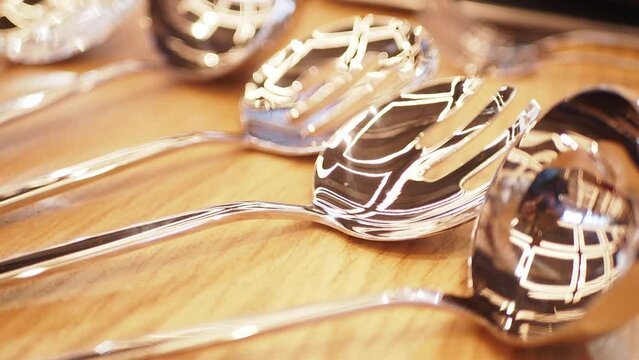 Shiny Silver Spoons on a Wooden Surface with Beautiful Reflections and Elegant Shine