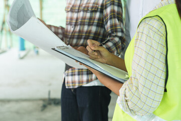 Asian contractor and engineer inspecting material in construction building.