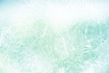 Blue water with ripples on the surface. Defocus blurred transparent blue colored clear calm water surface texture with splashes and bubbles. Water waves with shining pattern texture background.