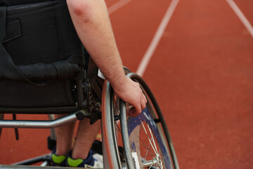 Close up photo of a person with disability in a wheelchair training tirelessly on the track in...