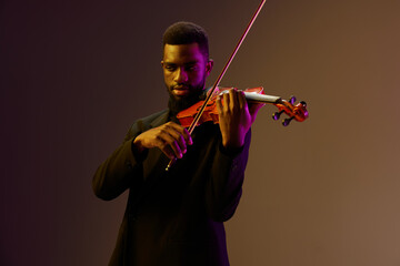 Elegant African American Man in Suit Playing Violin on Dark Background in Classic Musical Performance