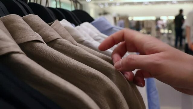 partial view of woman choosing clothing in boutique