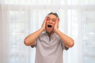 Sick unhappy senior elderly man touching head serious depressed feeling headache thinking of...