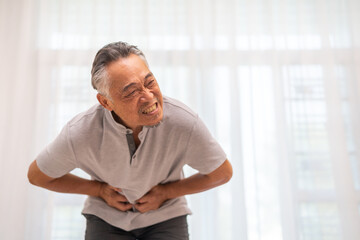 Senior asian elderly man sick unhappy touching belly stomach with suffering from stomach ache pain,...