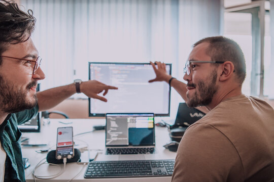 Programmers engrossed in deep collaboration, diligently working together to solve complex problems and develop innovative mobile applications with seamless functionality.