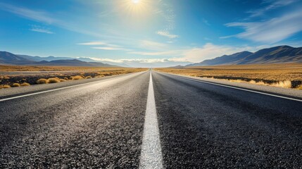Naklejka premium A long, empty road stretches towards the horizon, framed by mountains and a bright blue sky. The road symbolizes journey, opportunity, and the unknown.