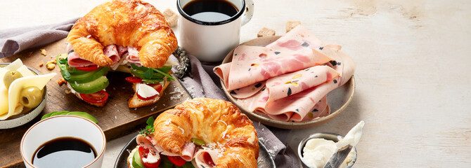 ..Croissant with ham and cheese on board and plate. Breakfast concept.
