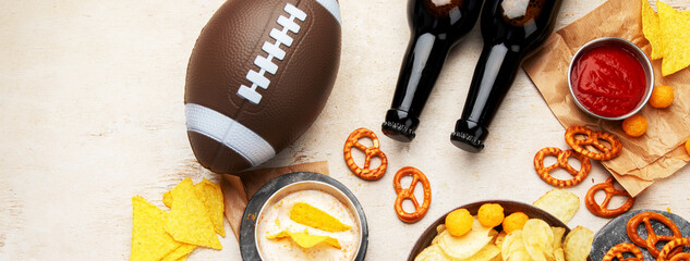 Snacks for watching an American football game. Beer, chips, pretzels, sauce on wooden background