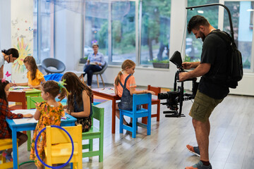 Cameraman films the joyful play and creative exploration of children at a preschool