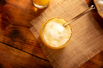 Pineapple cooler drink, served in a glass glass on a wooden table, in Mexico it is called Agua de Piña and is part of the traditional Aguas Frescas.